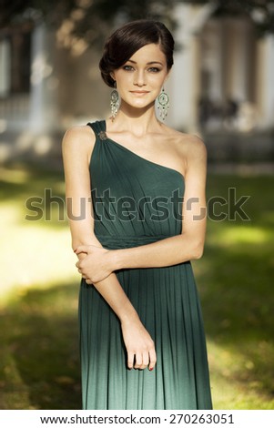 Beautiful young girl in a prom dress in the park