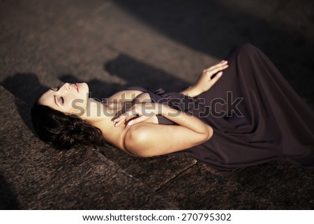 A woman in a long dress lying on the stairs