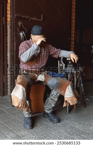 Image, Stock Photo Blacksmith forging horseshoe near stable