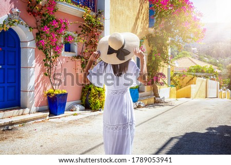A tourist woman in a white summer dress walks doen the colorful streets of the little village Assos on the island of Kefalonia, Greece Stockfoto © 