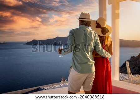 A romantic couple stands on the balkony and enjoys the beautiful summer sunset over the mediterranean sea with a glass of aperitif Zdjęcia stock © 