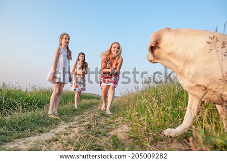 Family with dog. Mother with two children and dog playing on green meadow