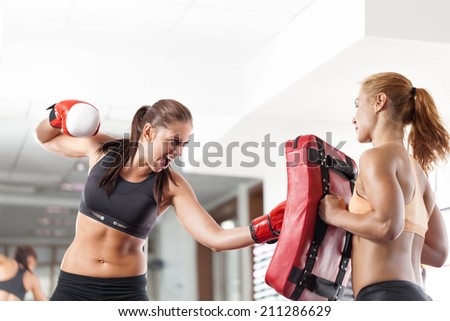 Two young pretty women boxing