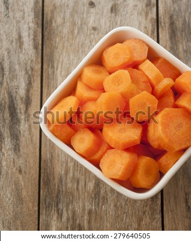 carrots cut in bowl close up on wooden background