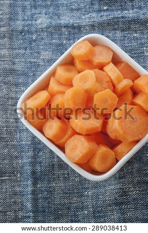 carrots cut in bowl close up on blue background
