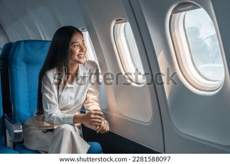 Similar – Image, Stock Photo young woman in airplane. Female tourist sitting by the open airplane window at sunset. People traveling by airplane, transportation, vacation concept.