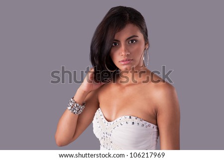 beautiful and sensual latin woman, holding their hair, looking to camera, studio shot