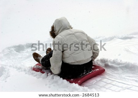 Child on a Sled in Snow - (Face not shown)