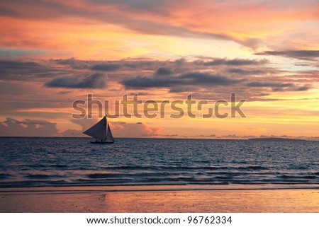 A sailboat was sailing on the beautiful sunset ocean.
