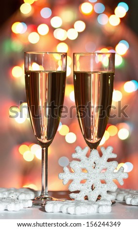 snowflake, christmas toys, wine glasses and santa against Christmas lights