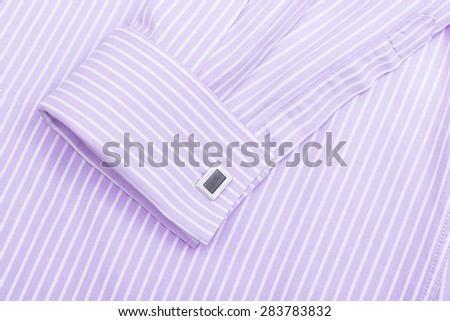 Sleeve of a striped pink shirt with a cuff link isolated on white background