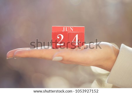 the woman is holding a red wooden calendar. Red wooden cube shape calendar for JUN 24 with hand ( kad?n eli k?rm?z? takvim) Stok fotoğraf © 