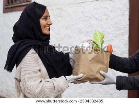 Similar – Image, Stock Photo Female volunteer delivering bags with shopping to elderly woman during coronavirus pandemic