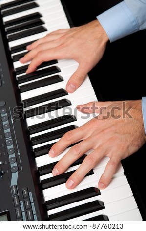 closeup shot of male hands playing the piano in the studio