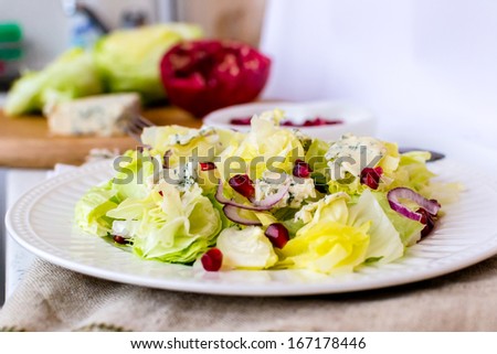 Iceberg lettuce with blue cheese and pomegranate seeds