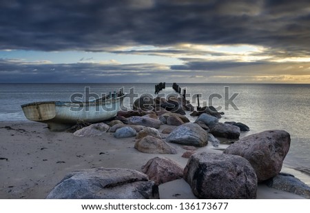 Fishing boat and remains of wooden pier after storm, Baltic Sea