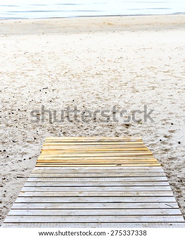 Wooden deck floor over a sand beach of the Baltic Sea