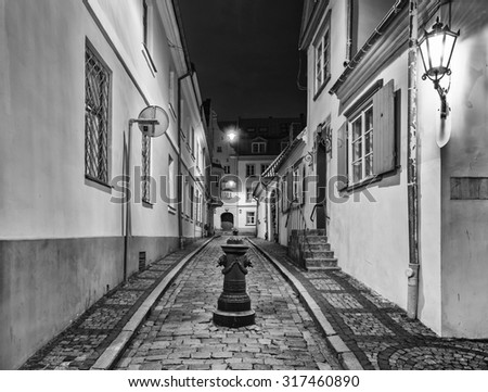 Night in the narrow street of old Riga city, Latvia. Image was toned with black and white filters for inspiration of retro style