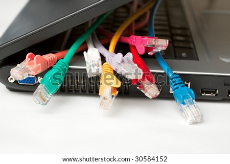 Multiple different coloured ethernet cables in a laptop computer