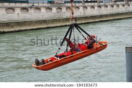 PARIS, FRANCE - MARCH 18, 2014: Firefighters of the elite GRIMP unit carry out a training exercise at the Pont Saint Michel on the River Seine. The unit specialises in rescues in hazardous situations.