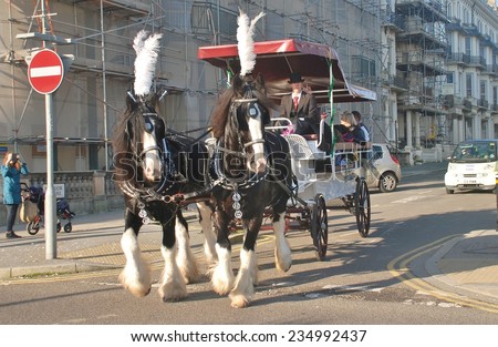 ST.LEONARDS-ON-SEA, ENGLAND - NOVEMBER 29, 2014: Horses pull a carriage giving rides around Warrior Square at the St.Leonards Frost Fair. The event promotes local trade in the approach to Christmas.