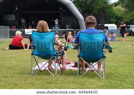 TENTERDEN, ENGLAND - JULY 3: Festival goers sit in chairs at the Tentertainment local music festival on July 3, 2010 in Tenterden, Kent. The festival is an annual event.