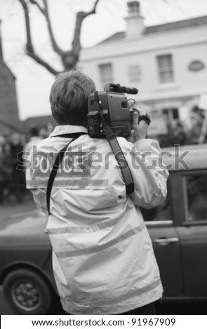 TENTERDEN, ENGLAND - DECEMBER 26: A police officer films anti hunt protestors at the Boxing Day meet of the Ashford Valley Hunt in the High Street on December 26, 1992 at Tenterden, Kent.