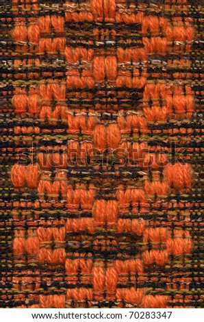 Macro detail of handwoven fabric with orange pattern