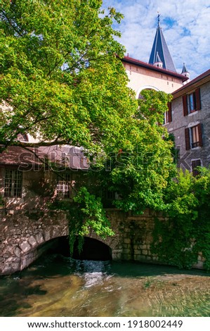 A building on a canal bridge in the city centre of Annecy, France near Jardin de l'Eveche with Eglise Notre Dame de Liesse in the background Photo stock © 
