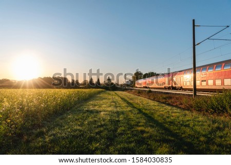 Similar – Image, Stock Photo Passenger train and rapeseed field. Spring landscape at sunrise