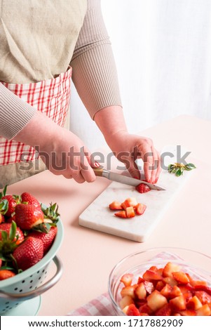 Similar – Image, Stock Photo Housewife making strawberry jam. Woman cutting fruits