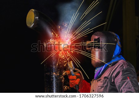 Similar – Image, Stock Photo A man welder with construction gloves and a welding mask hard work and welds with a welding machine metal in workshop, close up