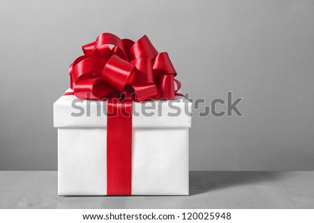 White gift box with red ribbon bow,