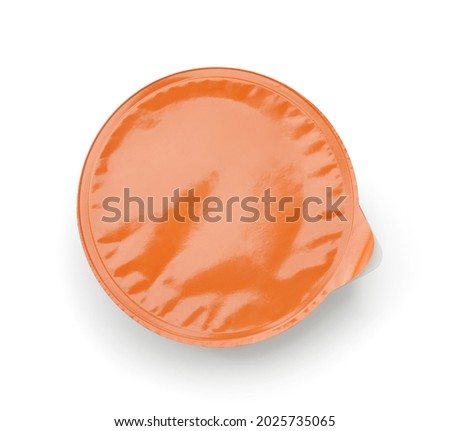 Top view of disposable plastic sauce cup with blank orange foil cover isolated on white Foto d'archivio © 