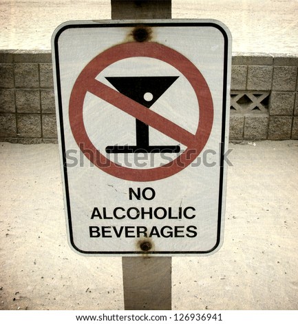 aged and worn vintage photo of  no alcoholic beverages sign on beach