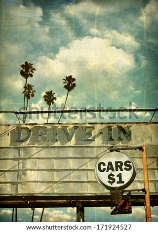 aged and worn vintage photo of drive in movie billboard with cars one dollar sign