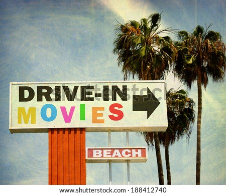 aged and worn vintage photo of retro drive in movies sign with palm trees
