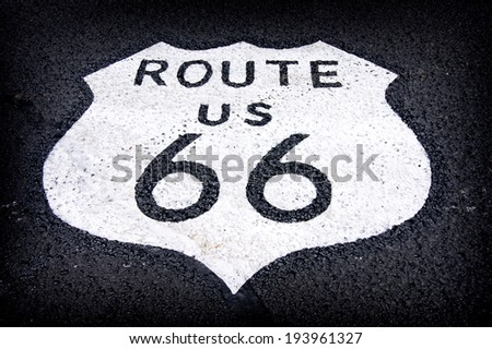 aged and worn vintage photo of route 66 sign on the road