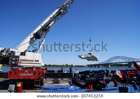 KENNEWICK, WA - JULY 25 : Hydroplane racing boat being lowered by crane as crew watches during Tri-Cities Water Follies annual event