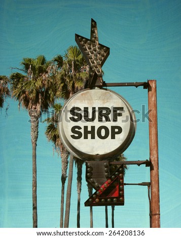 aged and worn vintage photo of surf shop sign with palm trees