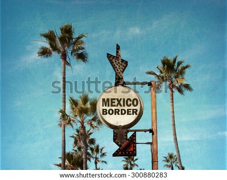 aged and worn vintage photo of mexico border sign with palm trees