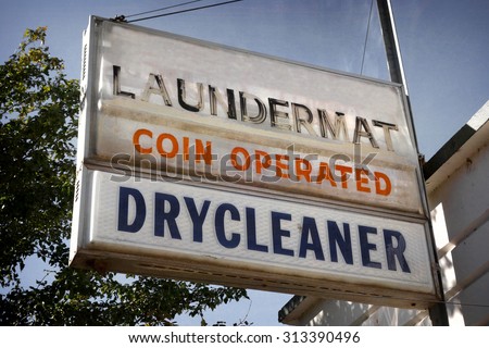 aged and worn vintage photo of laundromat and dry cleaners sign