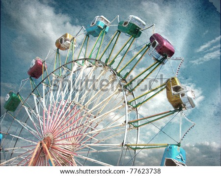 aged vintage photo of carnival ferris wheel with beautiful cloudy sky