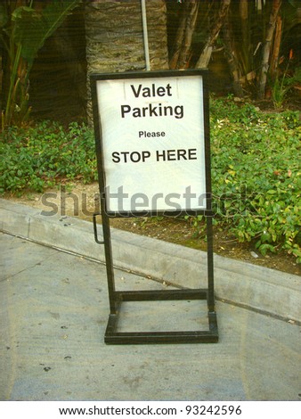 aged and worn vintage photo of  valet parking sign outside of business