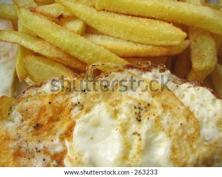 delicious fried eggs with chips, served straight off the frying pan, you can see the sizzling fat