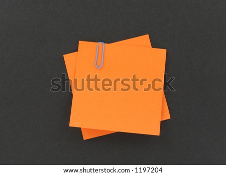 two post-it notes with a paperclip on black background