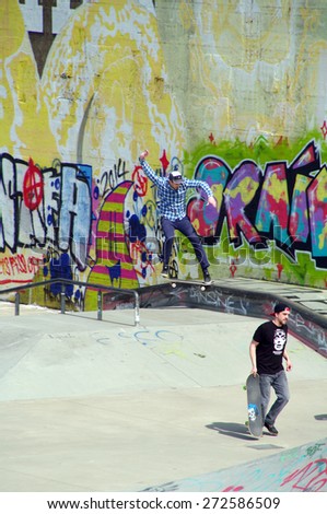 DUISBURG, GERMANY - 19 April 2015 The river bank Rhine. Skateboarders with friends in skate-park jumping in the halfpipe and on the other ramp