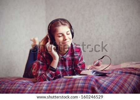 Pretty teenager hearing music on headphones