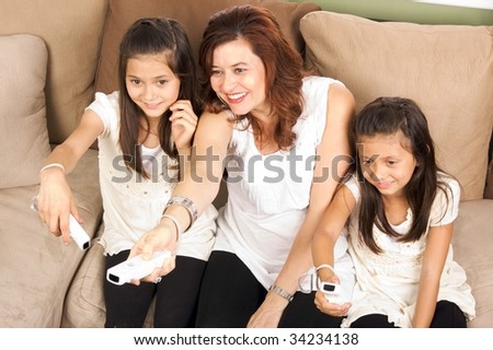 Family of mother and daughters playing video games together