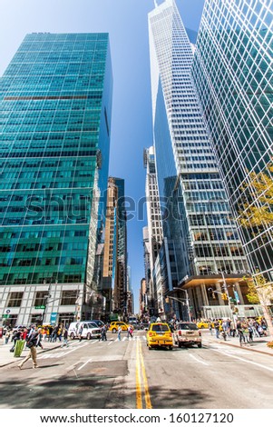 New York, United States - September 24, 2013: People are crossing the line over the street at the Bryant Park Corner under the skyscraper.
